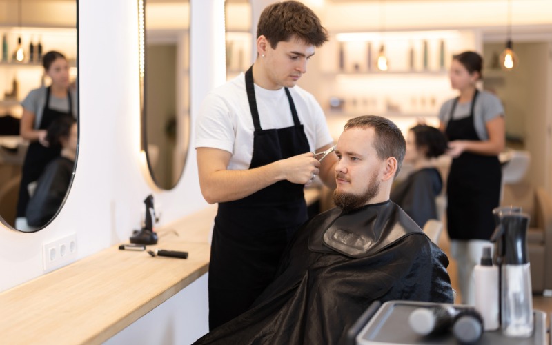 Peluquero cortando el cabello a un cliente en una peluquería